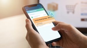 Mains tenant un smartphone affichant une notification de débit de 500$ provenant de Infinite Remit Services.